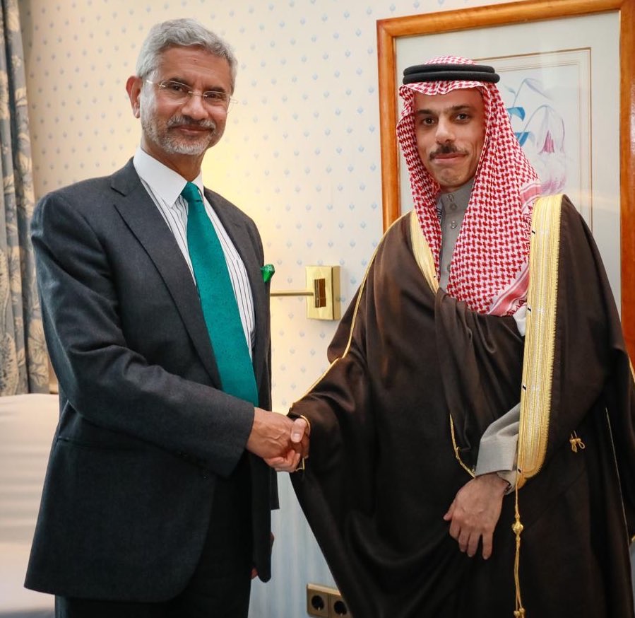 Faisal bin Farhan Al-Saud shaking hands with India's External Affairs Minister S. Jaishankar in a hotel room